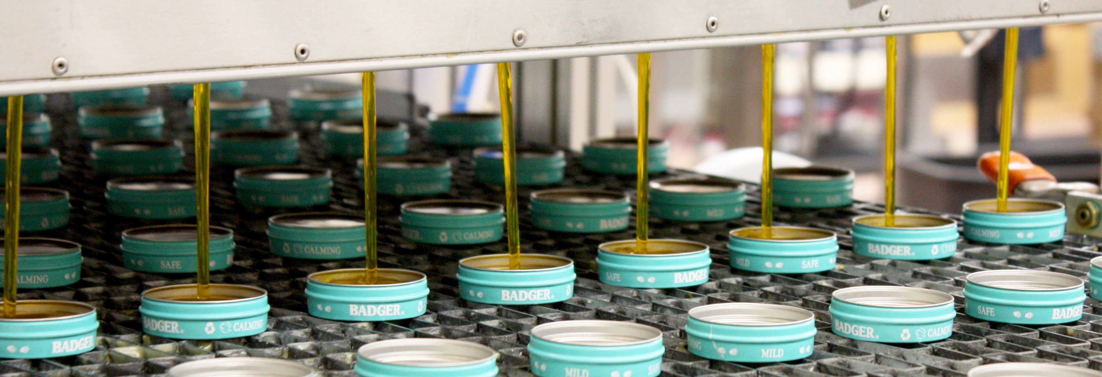 Badger Baby Balm tins being filled on the line